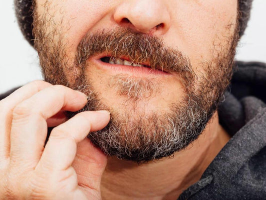 a man scratching his beard